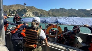 Miembros de la Armada Nacional de Colombia y personal ambiental colaborando durante un operativo marítimo, supervisando las actividades en una embarcación frente a las playas de Santa Marta.